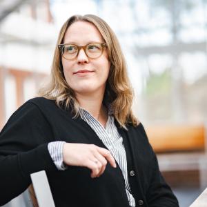 Amy Johnson sits on a chair and looks off to the side.