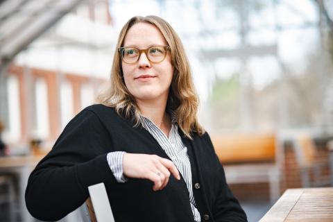 Amy Johnson sits on a chair and looks off to the side.